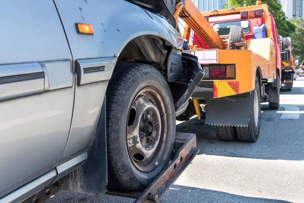 Tow Truck Towing A Broken Car Due To Accident — Trade & General Towing In Sandgate NSW