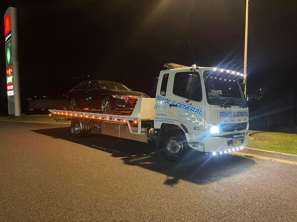 Towing The Black Car At Night — Trade & General Towing in Wallsend, NSW