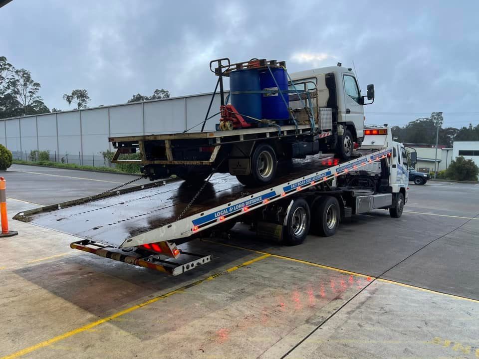 Towing the Truck With Two Water Containers — Trade & General Towing in Nelson Bay, NSW