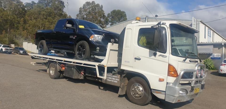 White Towing Truck Towed the Black Pick Up Vehicle — Trade & General Towing in Sandgate, NSW