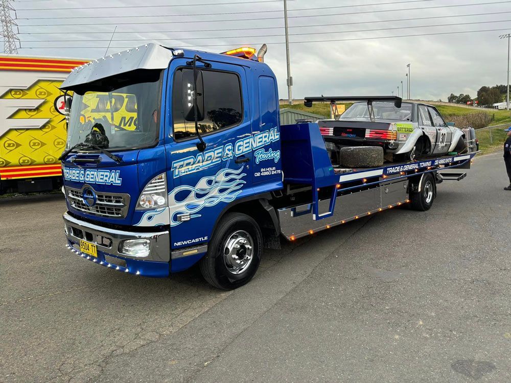 Truck Towing a Black Sports Car — Trade & General Towing in Sandgate, NSW