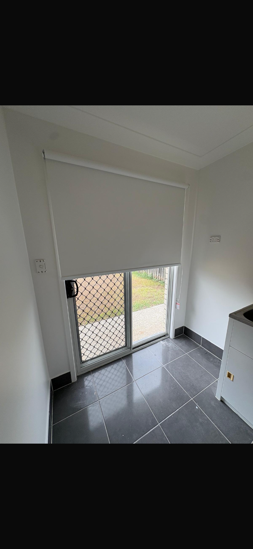 Small room with white walls, tiled floor, and a sliding glass door with a mesh screen.