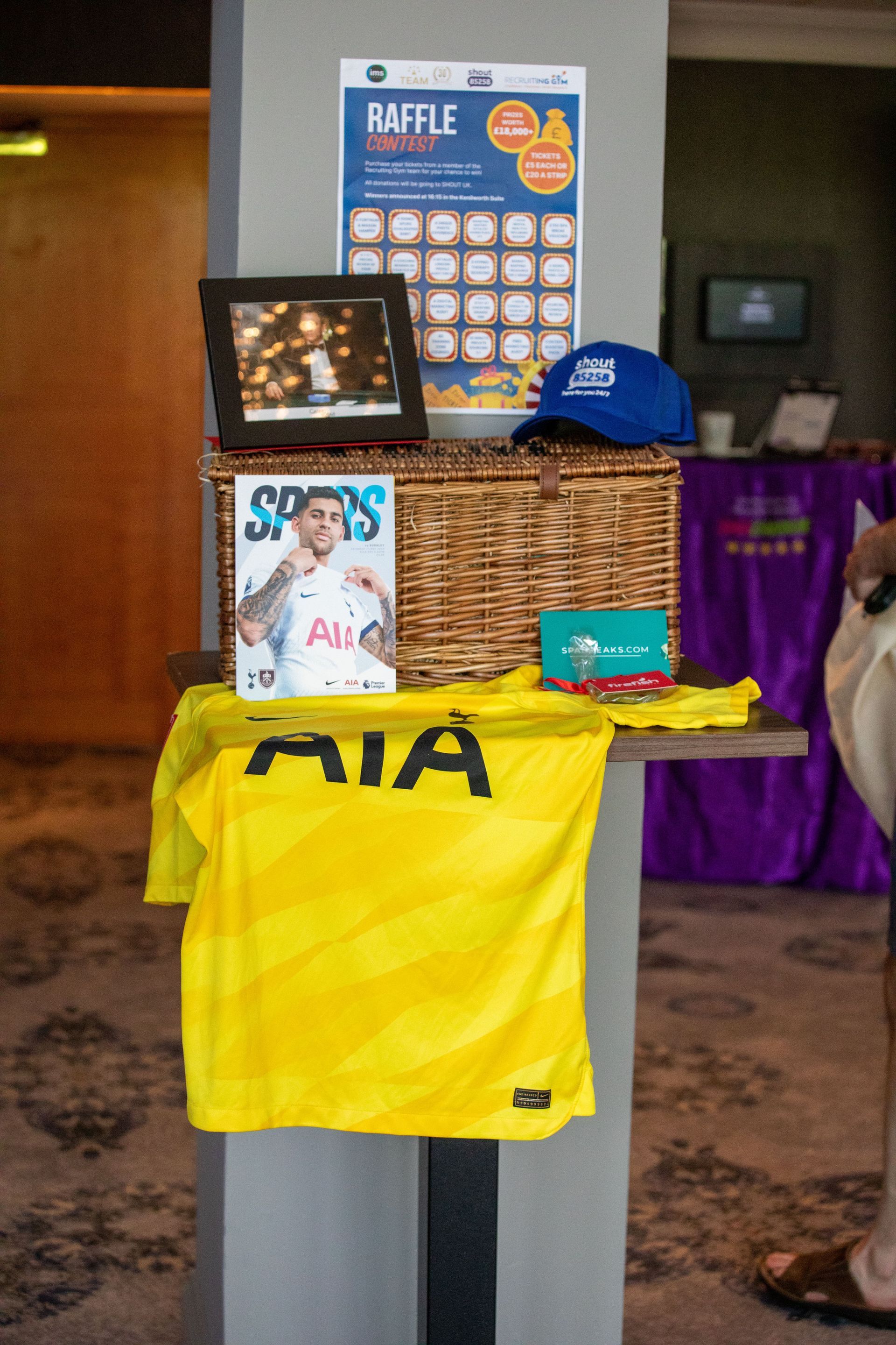 A yellow shirt is sitting on a table next to a basket.