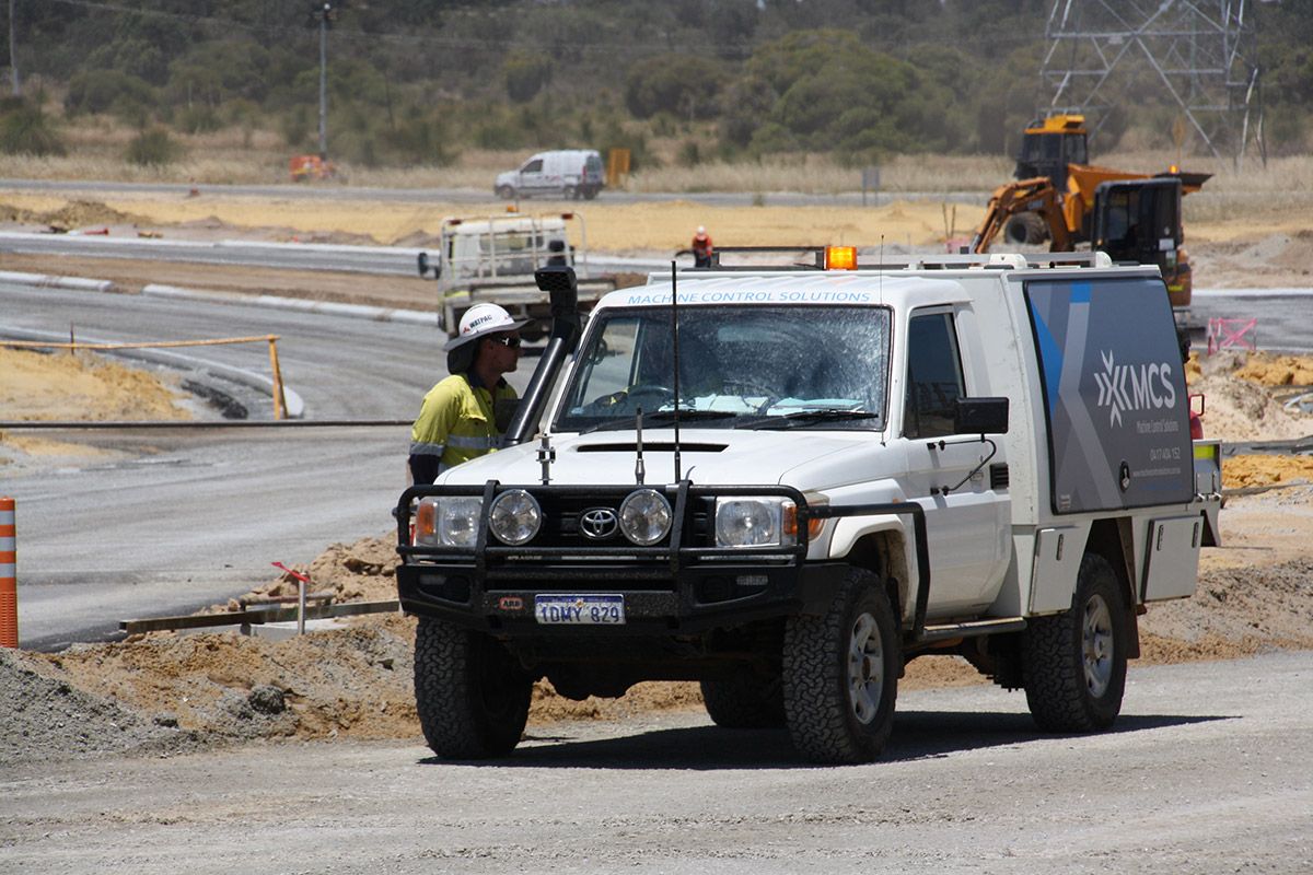 A row of construction vehicles are parked next to each other on a construction site.