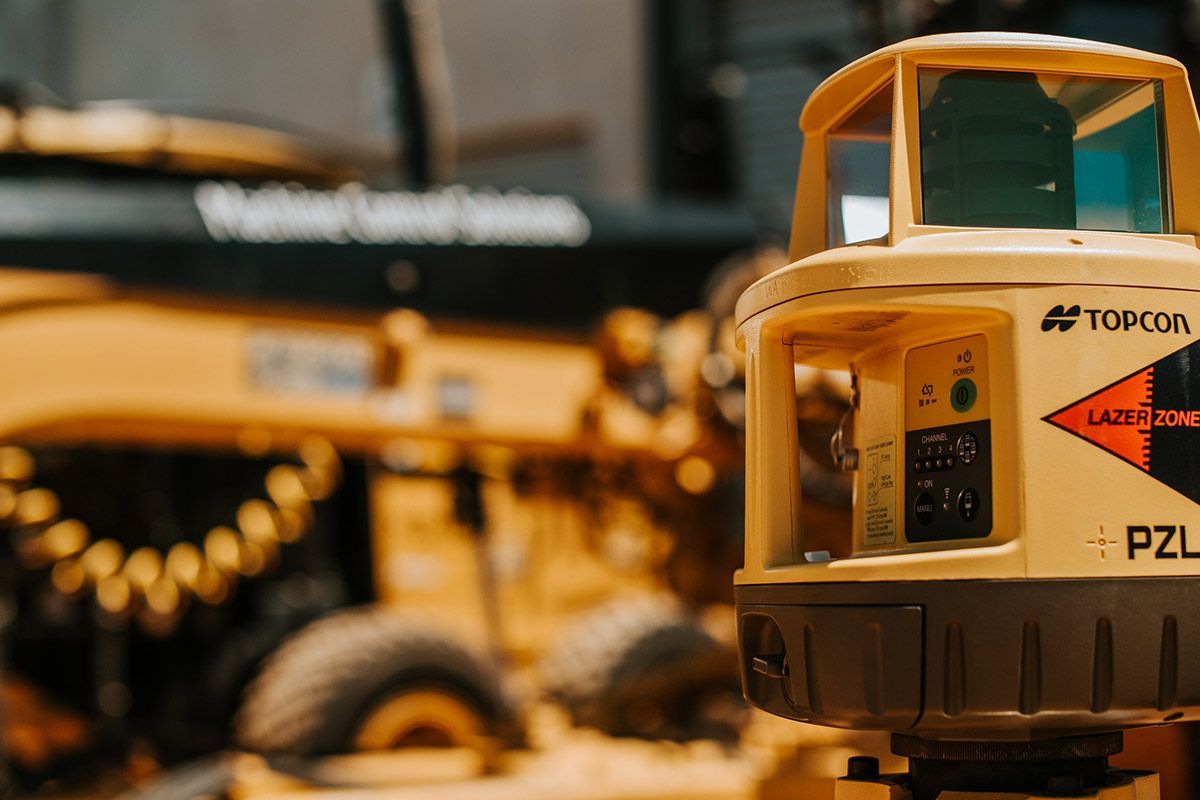 A row of construction vehicles are parked next to each other on a construction site.