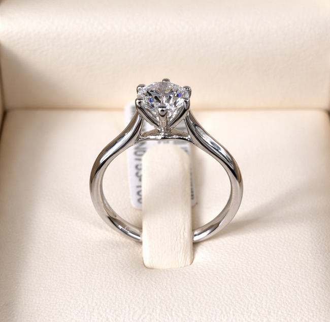 Anello di fidanzamento con diamante, con una grande pietra centrale quadrata e una fascia curva incastonata con diamanti più piccoli.
