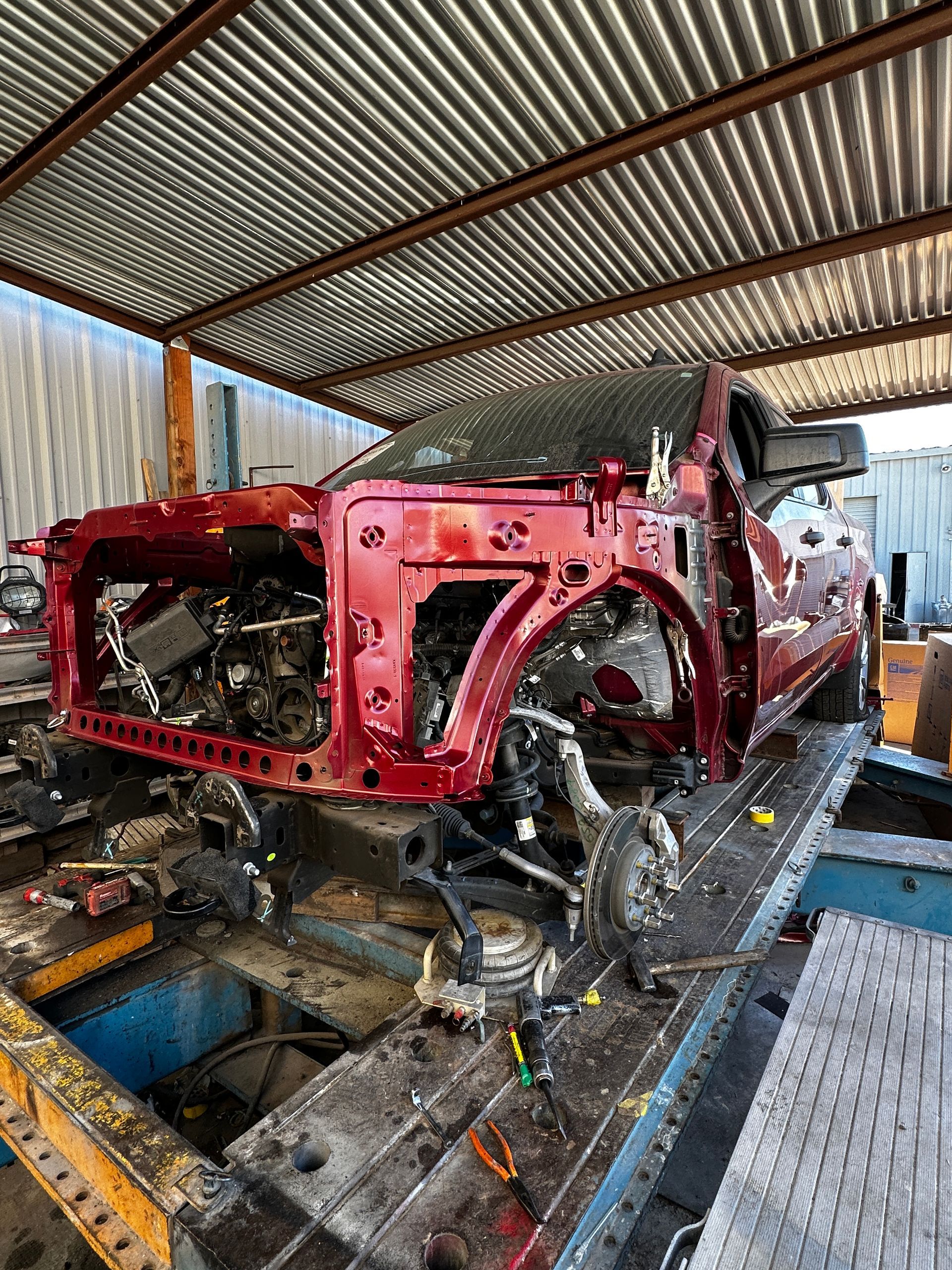 Car undergoing structural frame work in collision shop