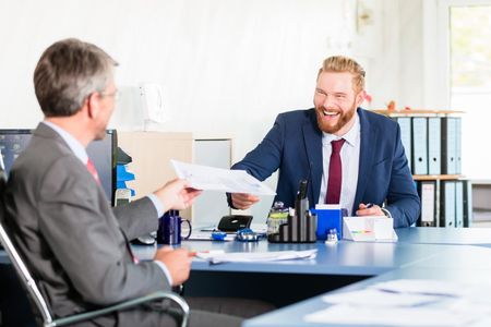 office worker handling the paper to the client