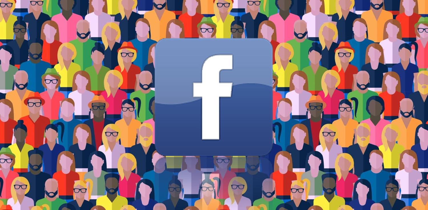 a large group of people are gathered around a facebook logo .