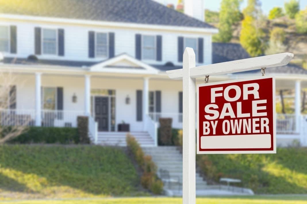 a house with a for sale sign in front of it