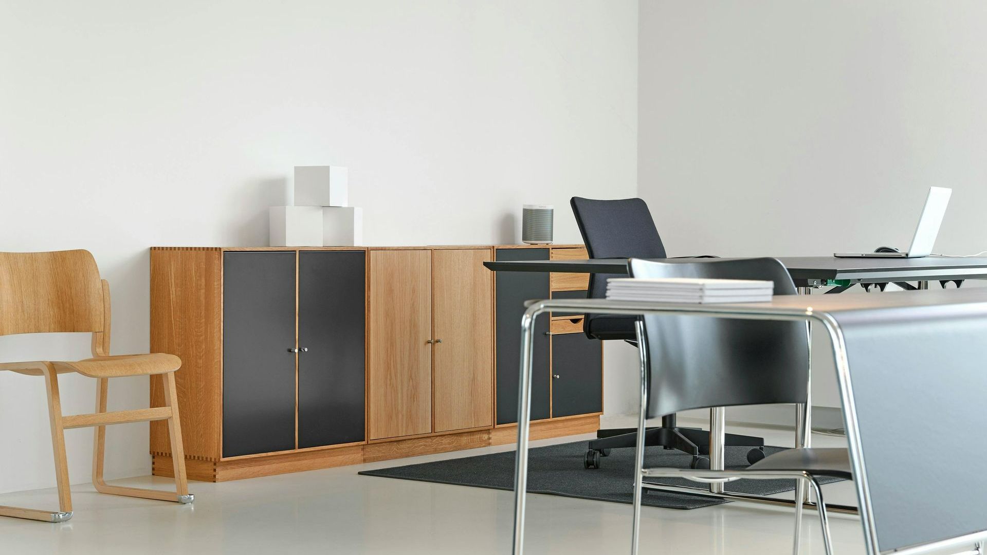An office with a desk and chairs and a wooden cabinet