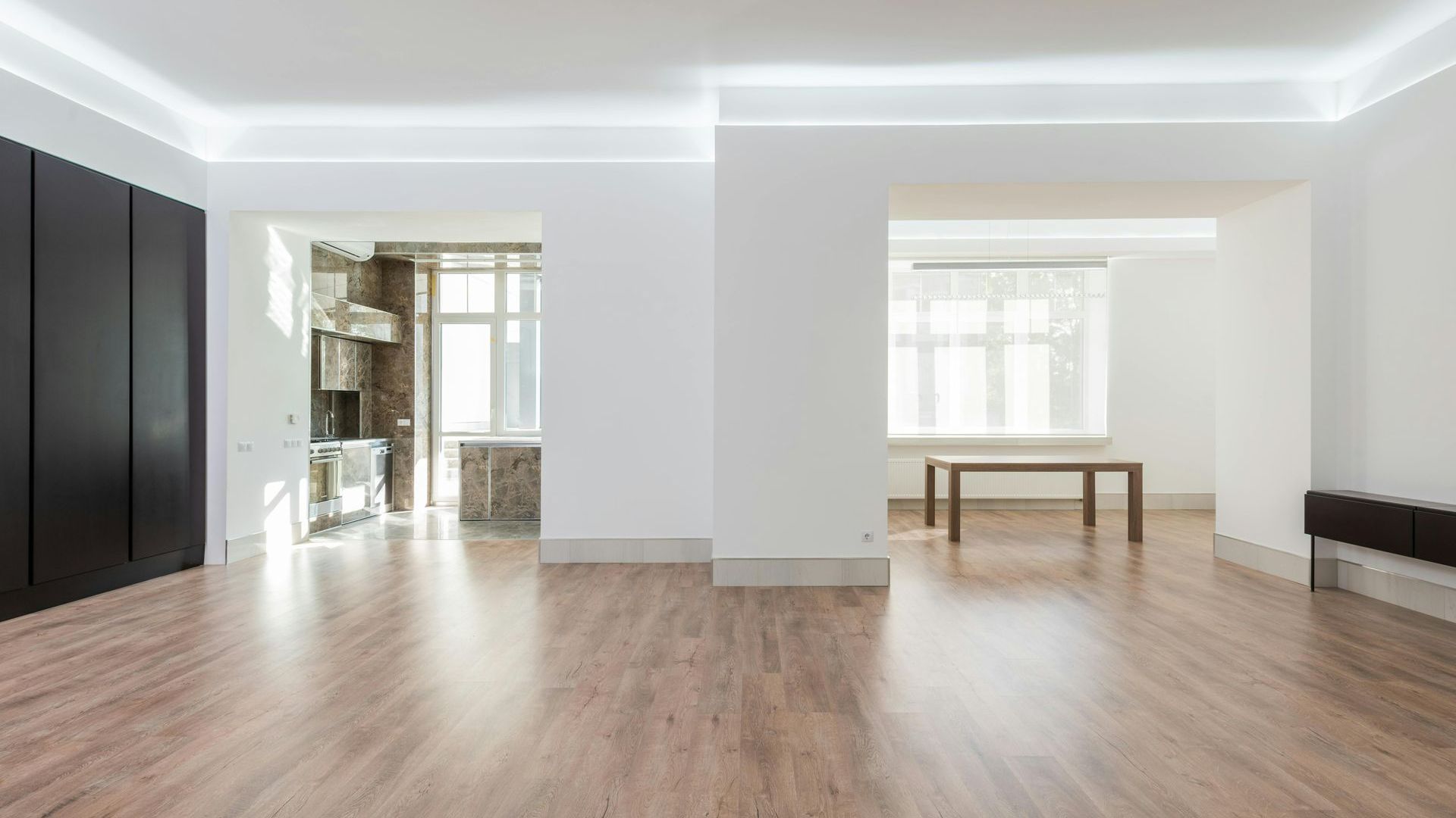 A large empty room with hardwood floors and white walls.