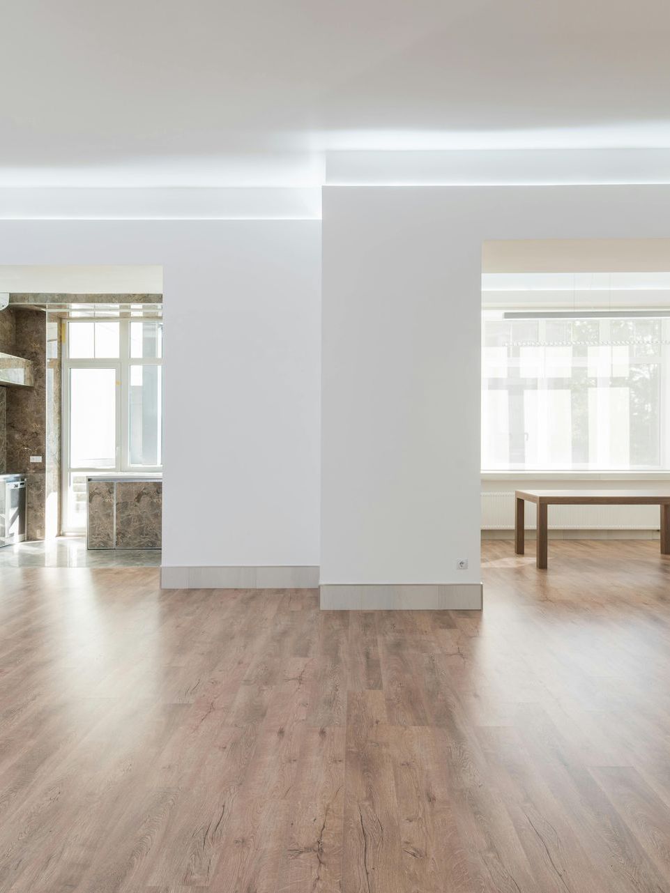 A large empty room with hardwood floors and white walls.