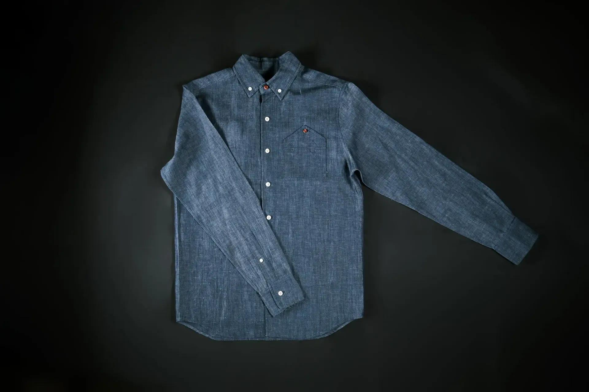 A blue shirt is laying on a black surface.