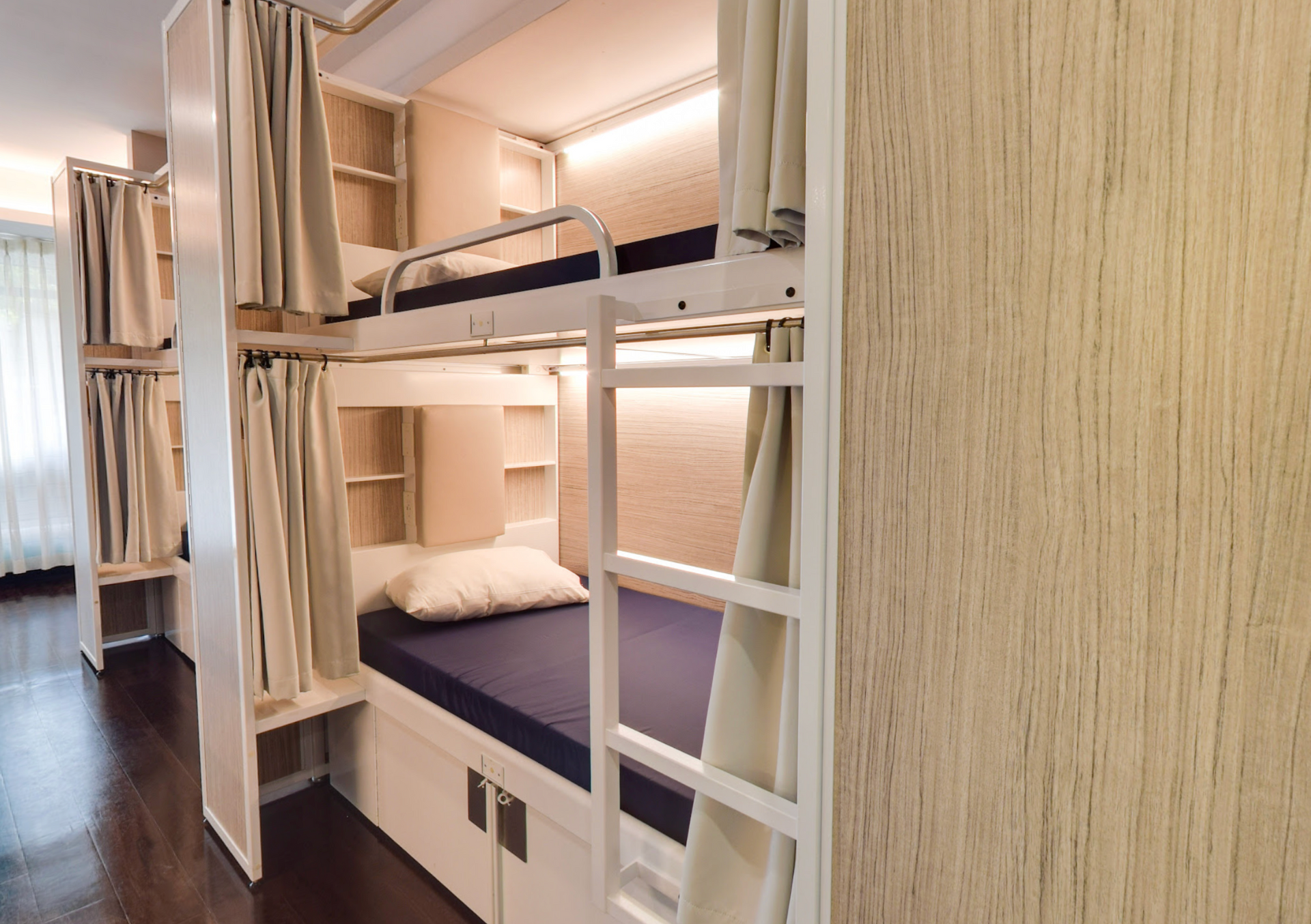 Lits superposés dans une chambre avec cadres blancs et matelas bleus.