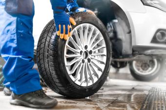 A person is changing a tire on a car.