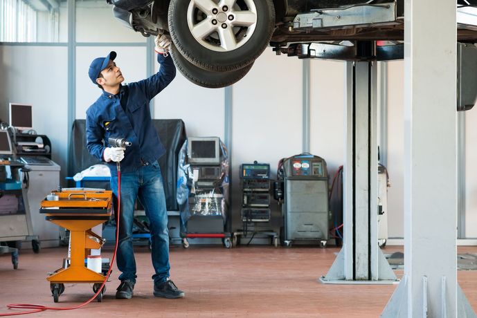 A mechanic is working on a car in a garage.