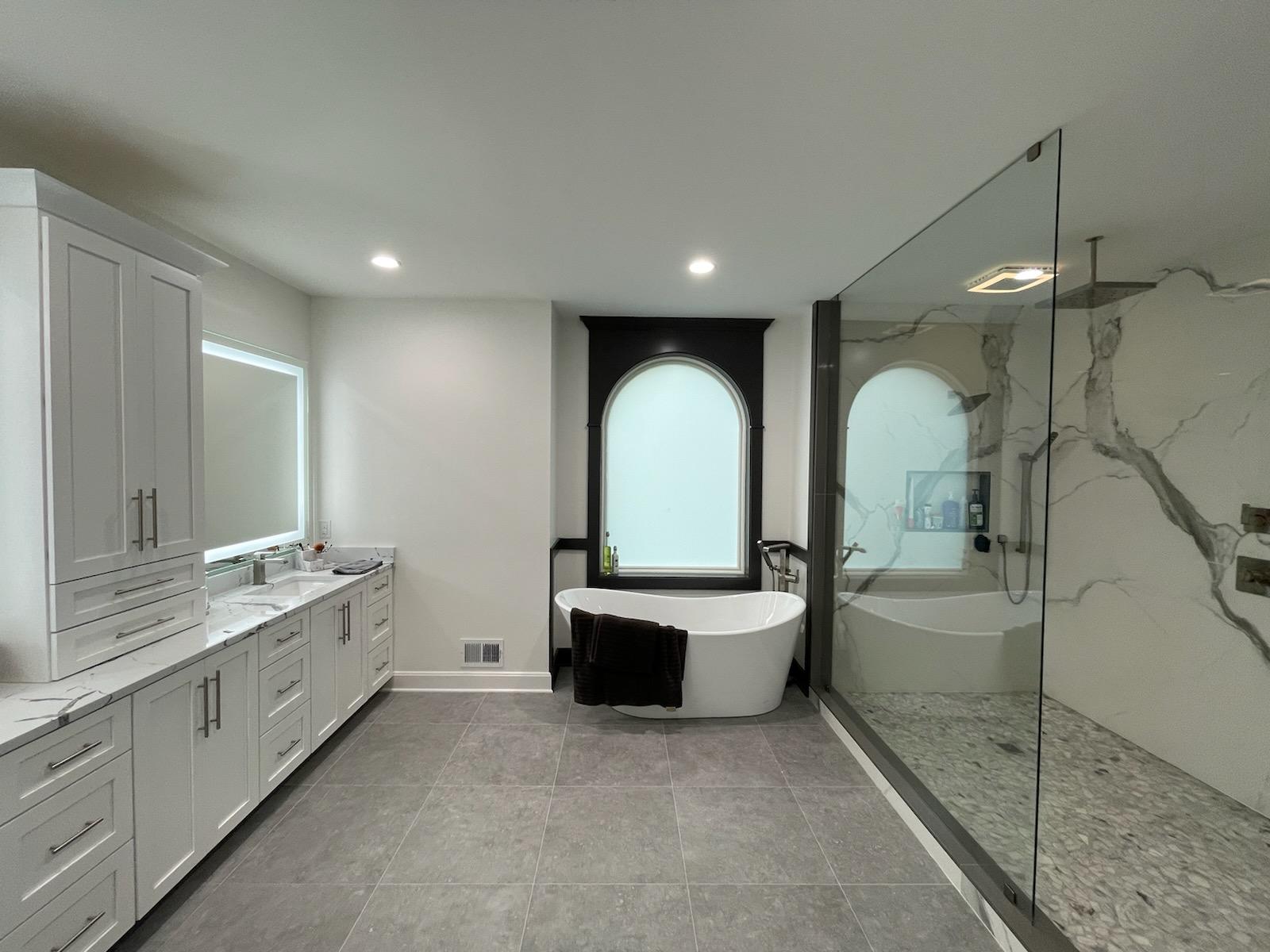 Modern bathroom with a white freestanding tub and a glass shower.