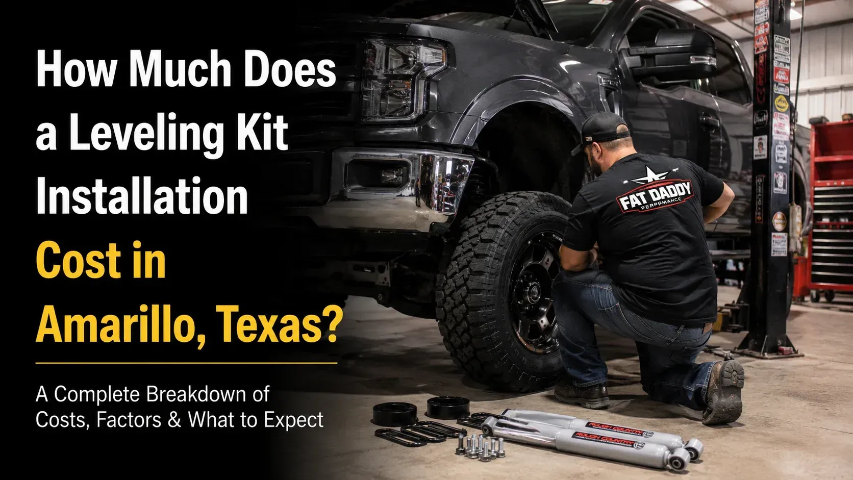 A technician working on the front wheel and suspension of a lifted truck inside a garage, demonstrating the process of how much does a leveling kit installation cost at Fat Daddy Performance.