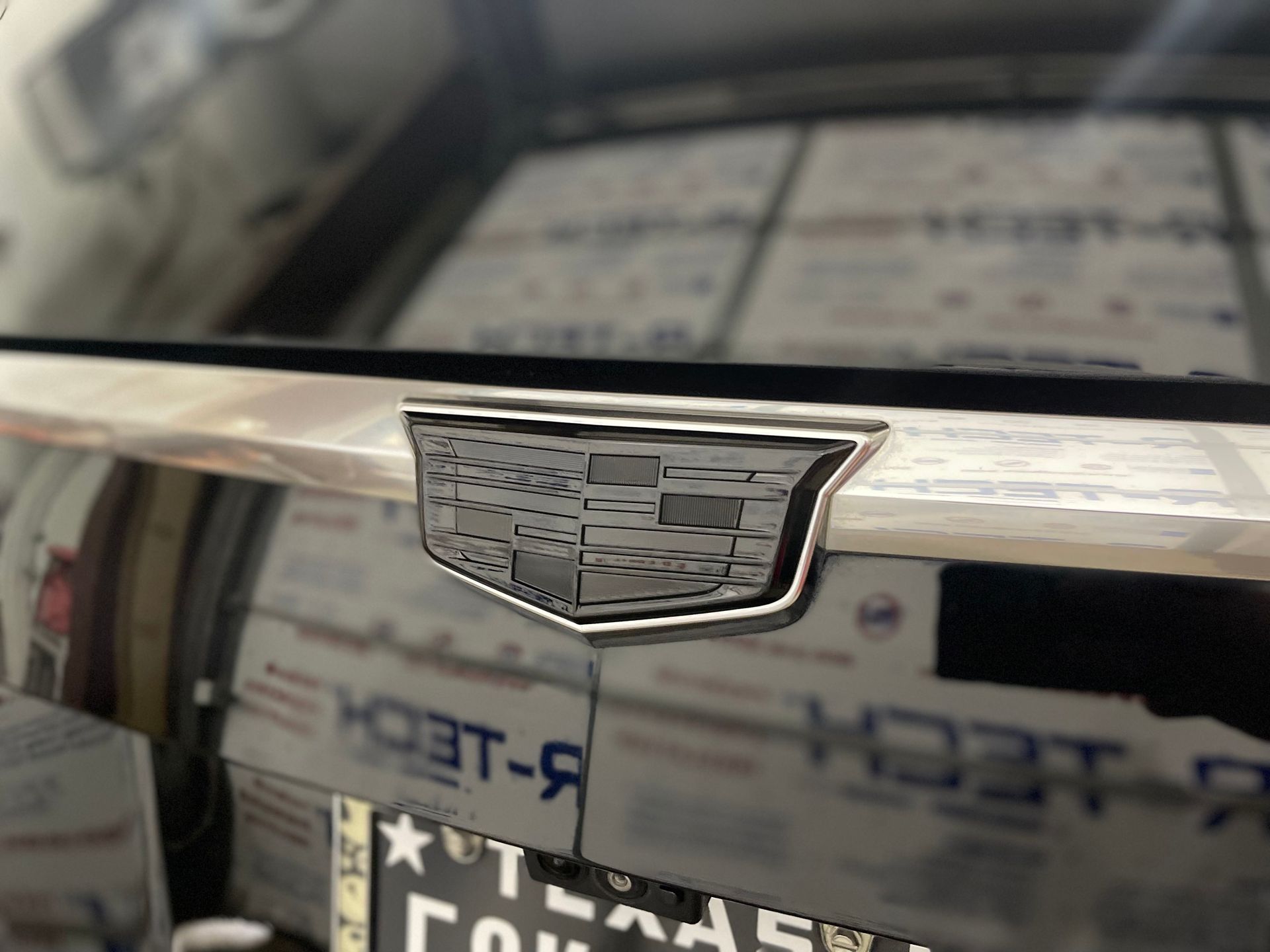 Black Cadillac emblem on rear of vehicle.