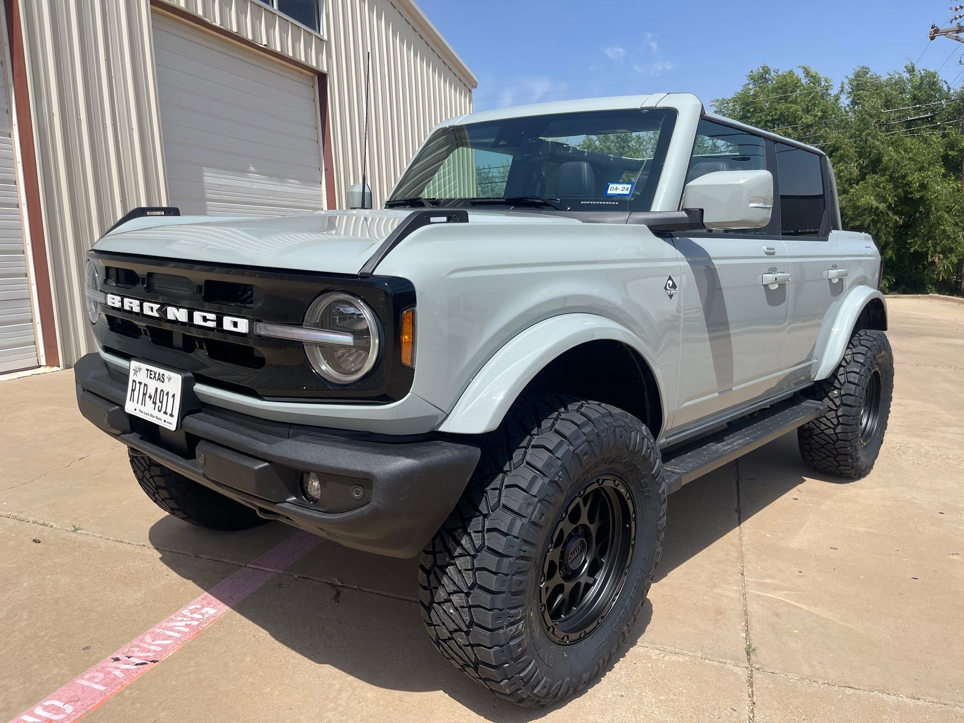 Gray Ford Bronco SUV parked outside. Black wheels, tinted windows.