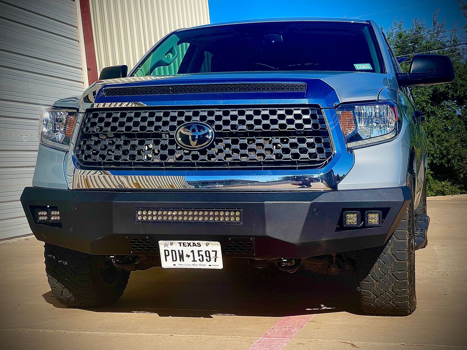 Silver Toyota Tundra pickup truck with a black front bumper, Texas license plate, and LED light bar.