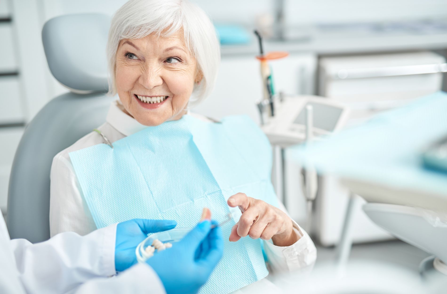 An elderly woman discussing denture options with a dentist.
