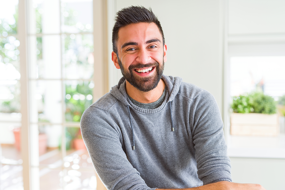guy smiling sitting inside showing off his smile