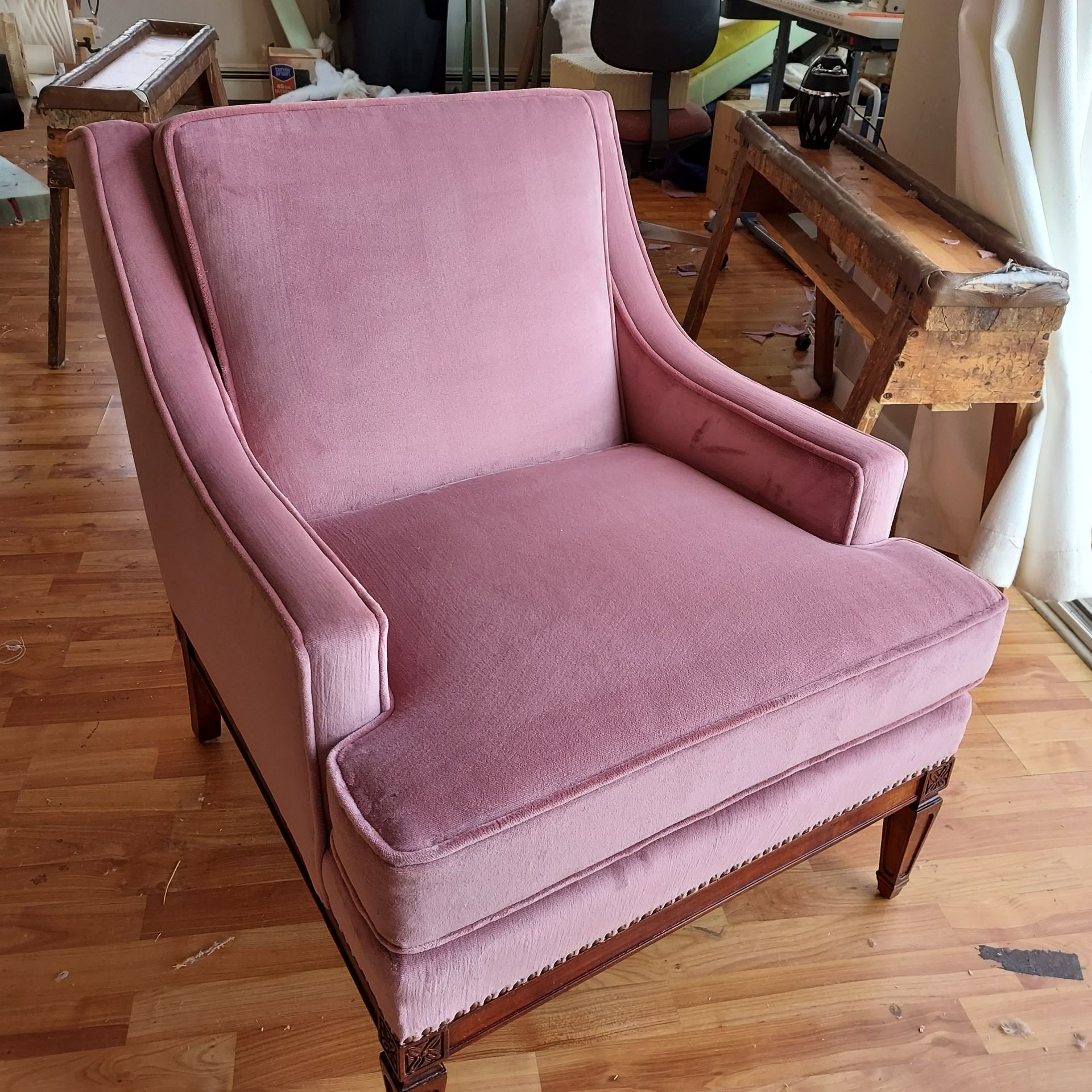 A wooden rocking chair is sitting on a wooden floor in a living room.