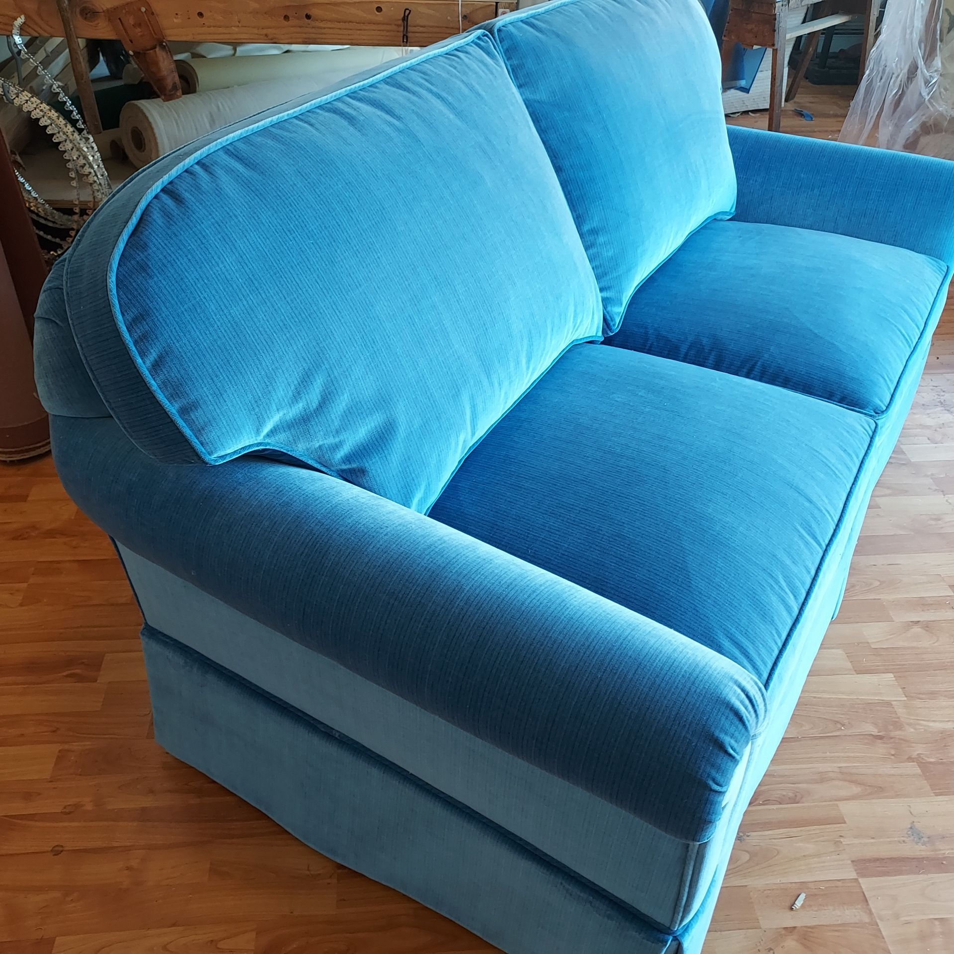 A blue chair with a white pillow on it.