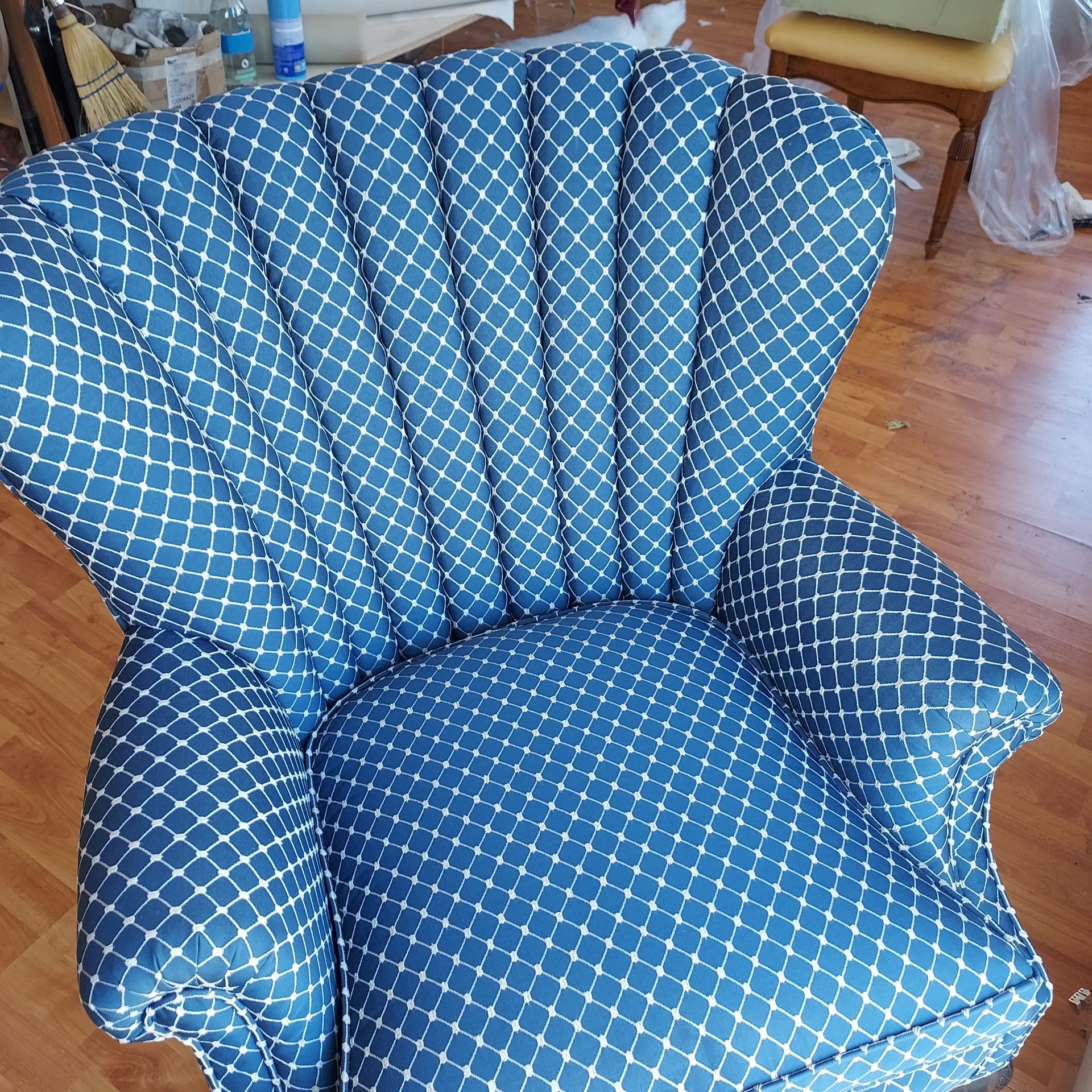 A blue and white chair is sitting on a wooden floor.