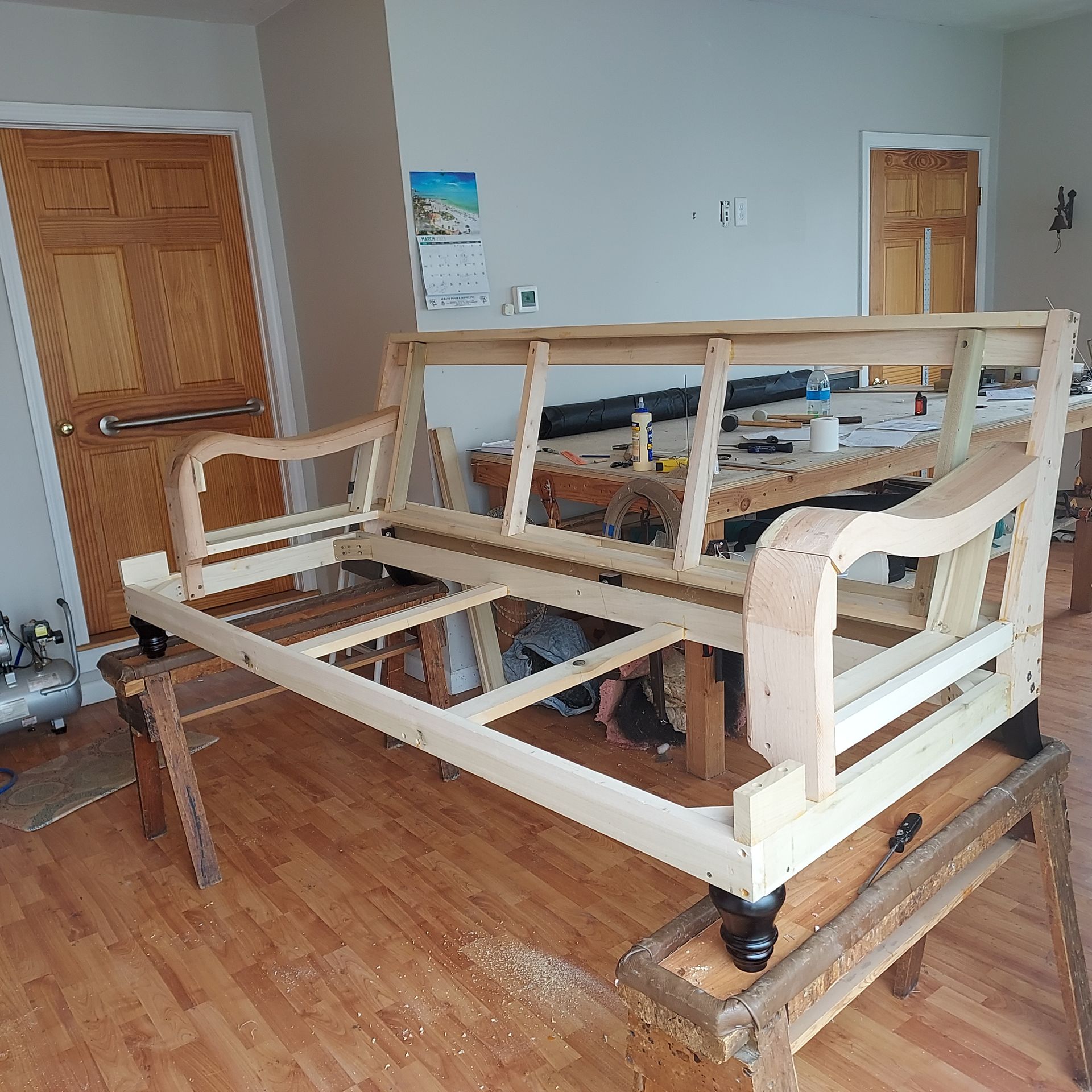 A wooden couch is being built in a living room.