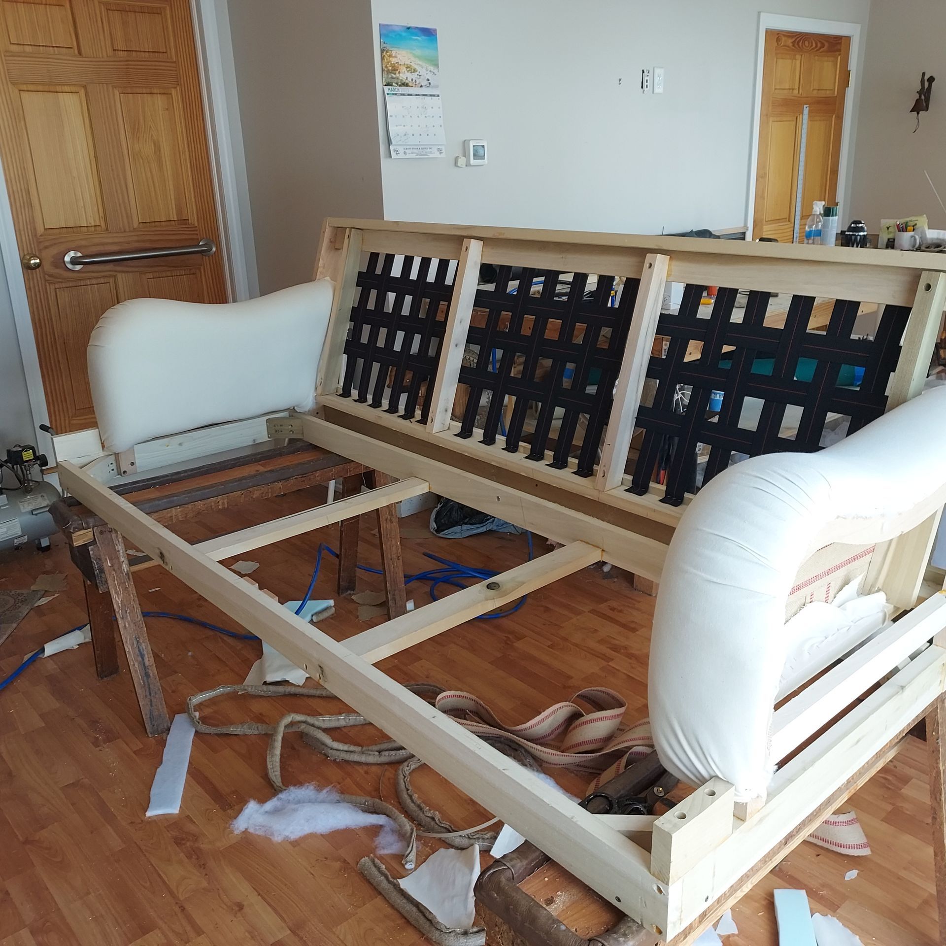 A wooden couch is being built in a living room.