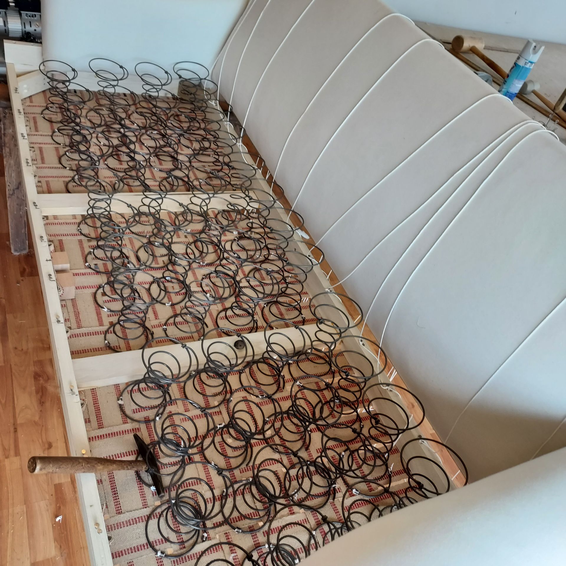 A couch with springs and a hammer on it
