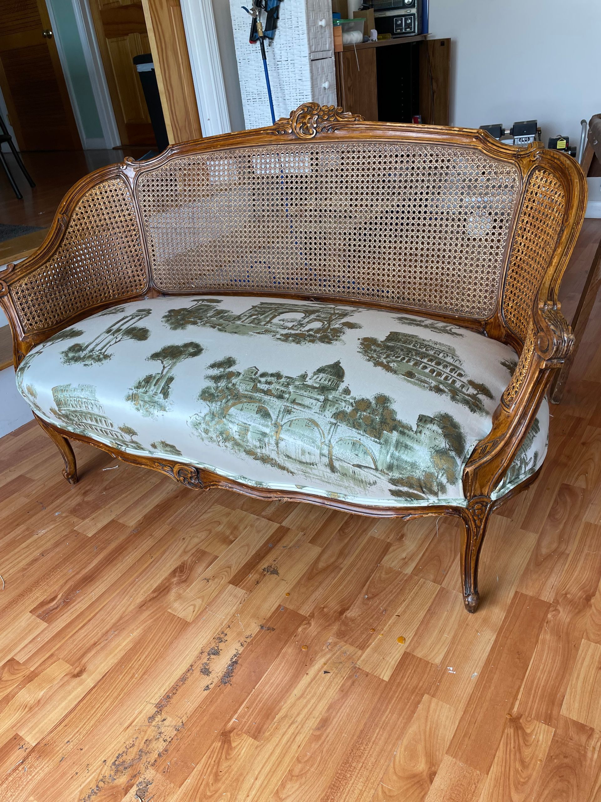 A purple couch and a white chair are sitting next to each other on a wooden floor.