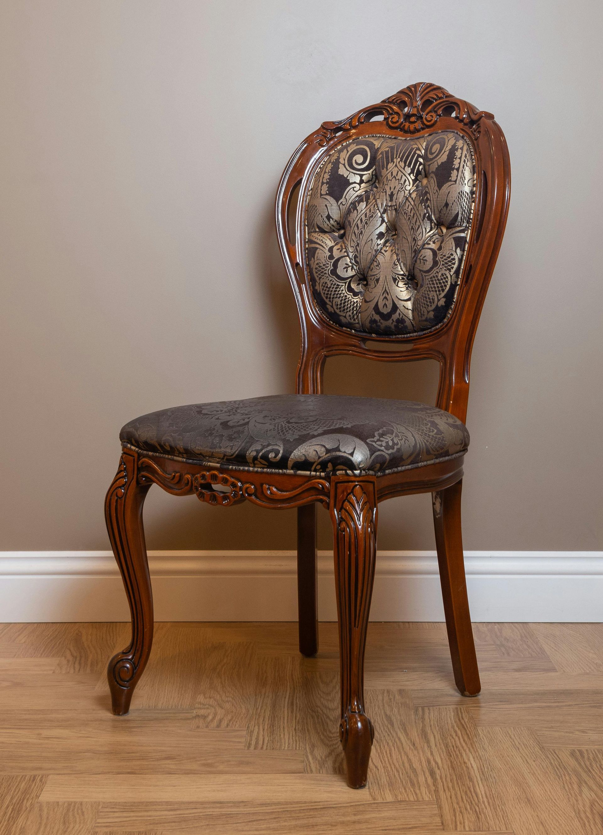 A wooden chair is sitting on a wooden floor next to a wall.
