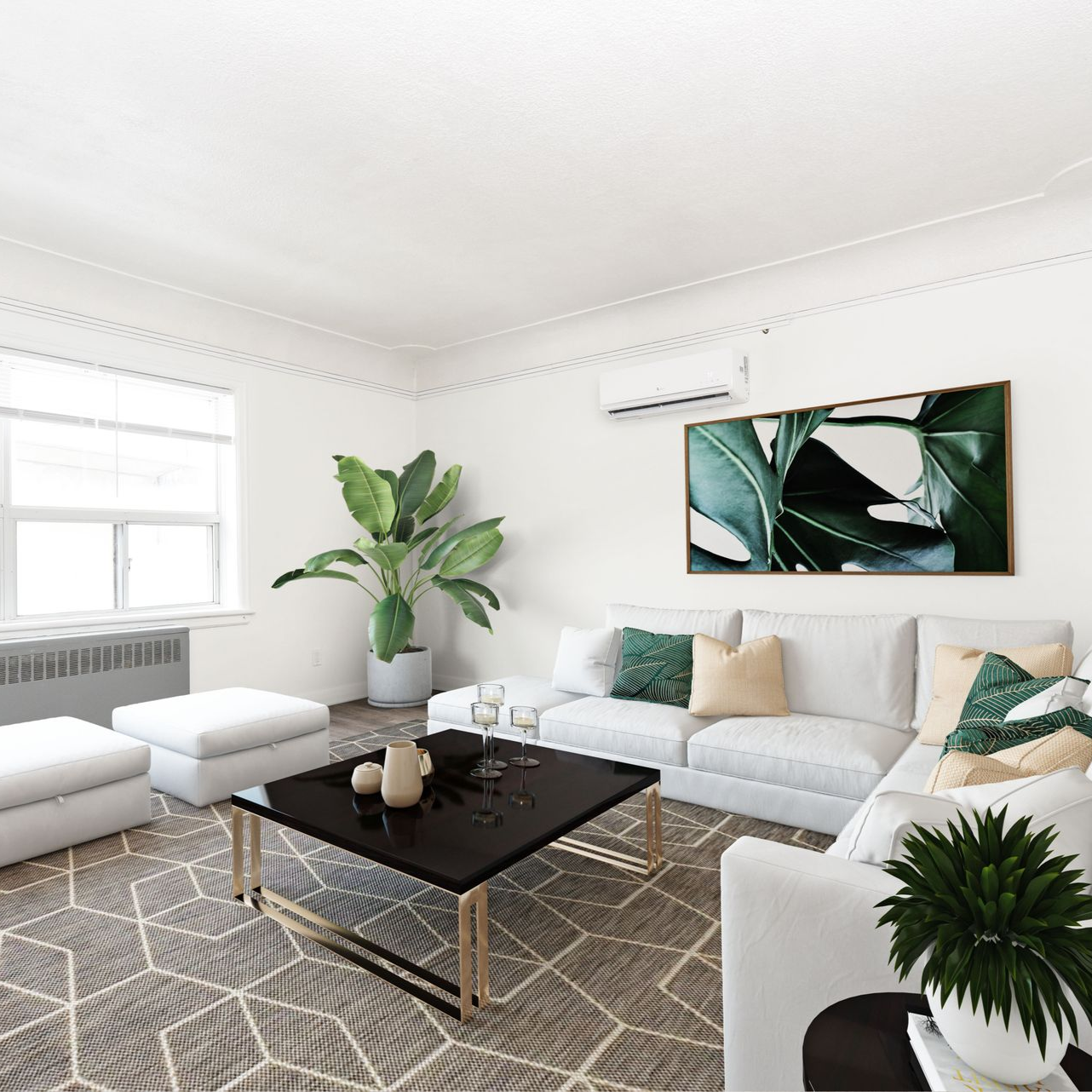 Bright modern living room with white sectional sofa, black coffee table, green plants, and gray patterned rug
