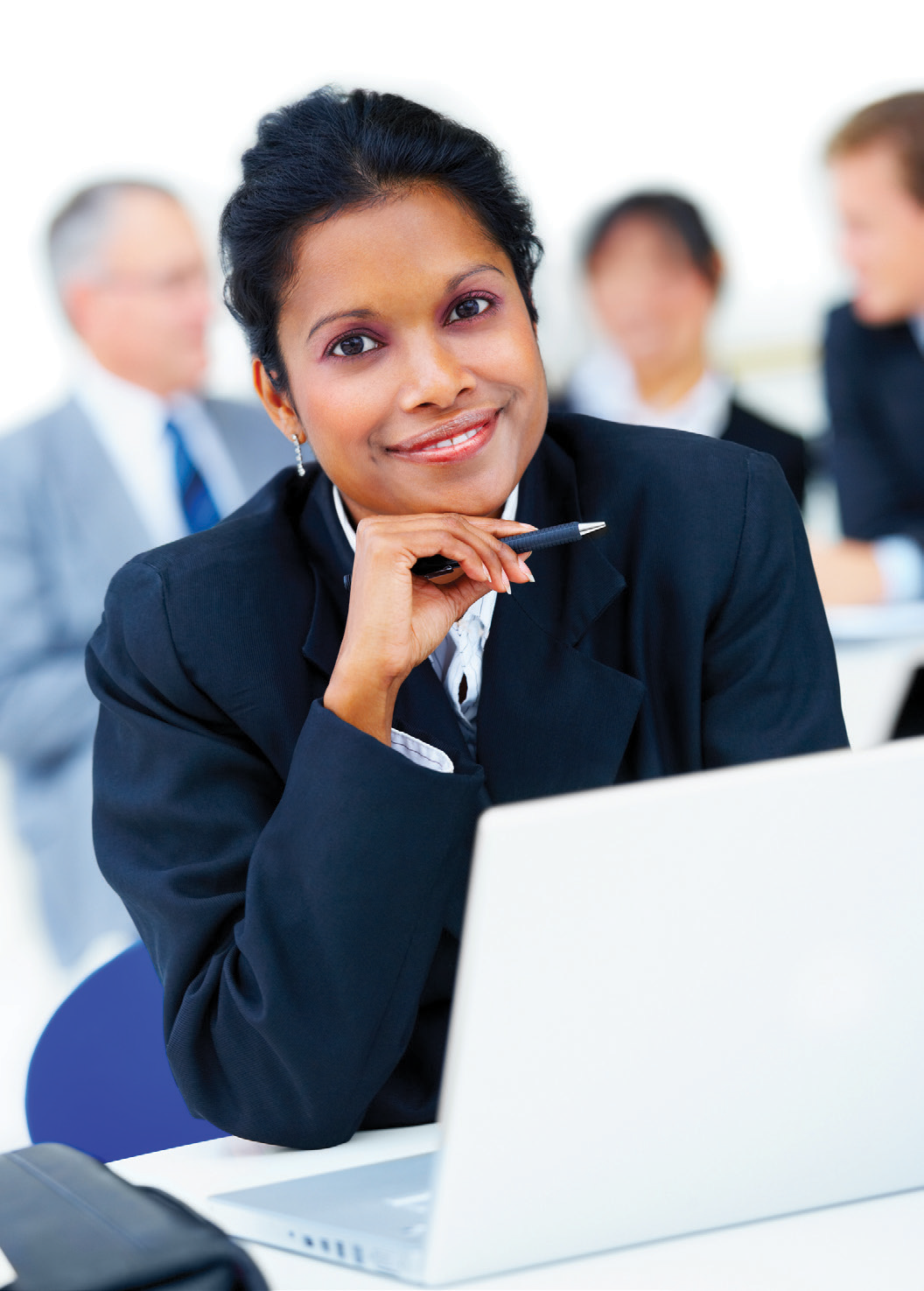 A woman in a suit is sitting in front of a laptop computer