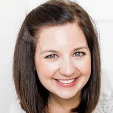 A woman with brown hair is smiling for the camera.