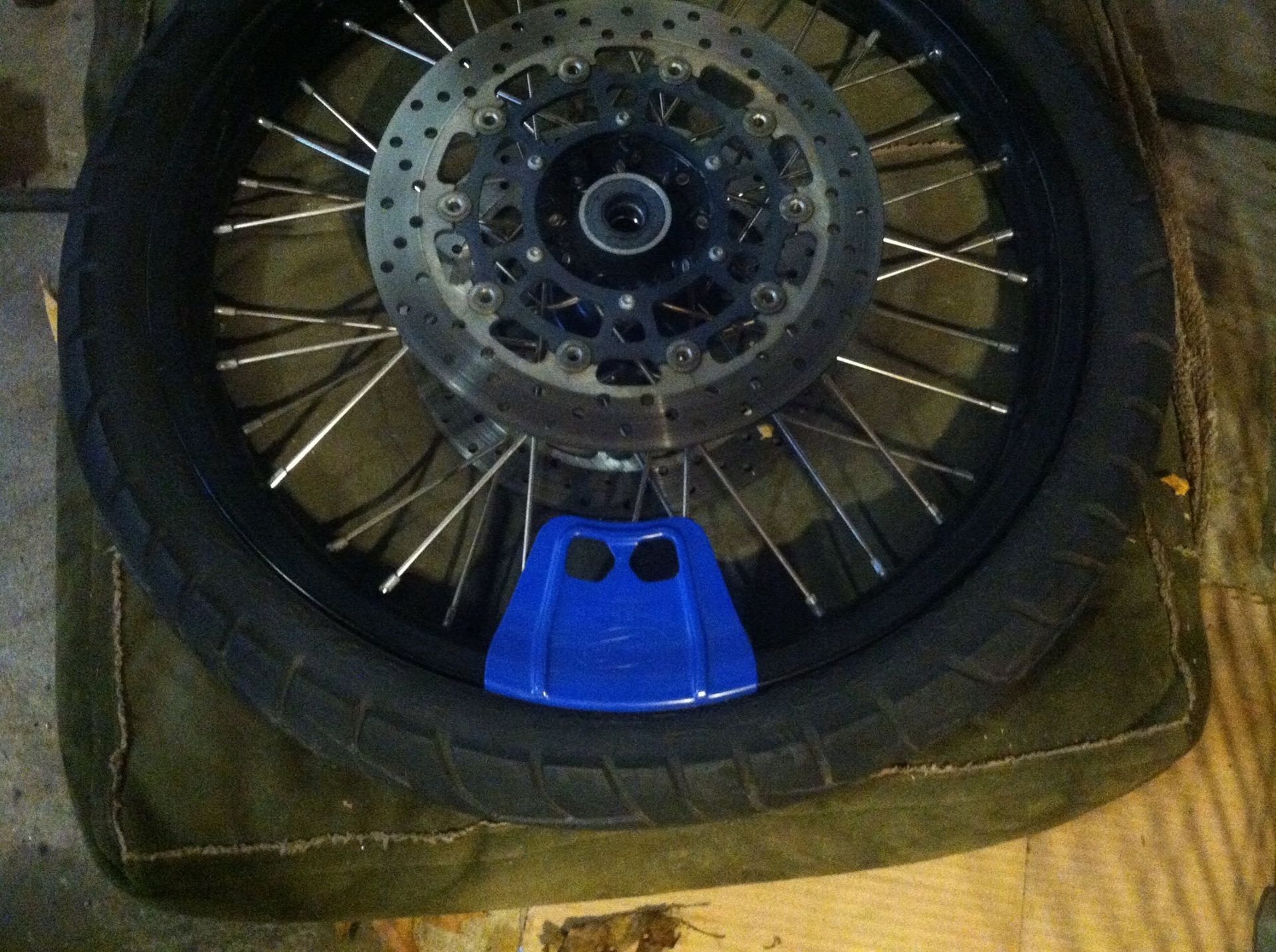 A motorcycle wheel with a blue padlock on it