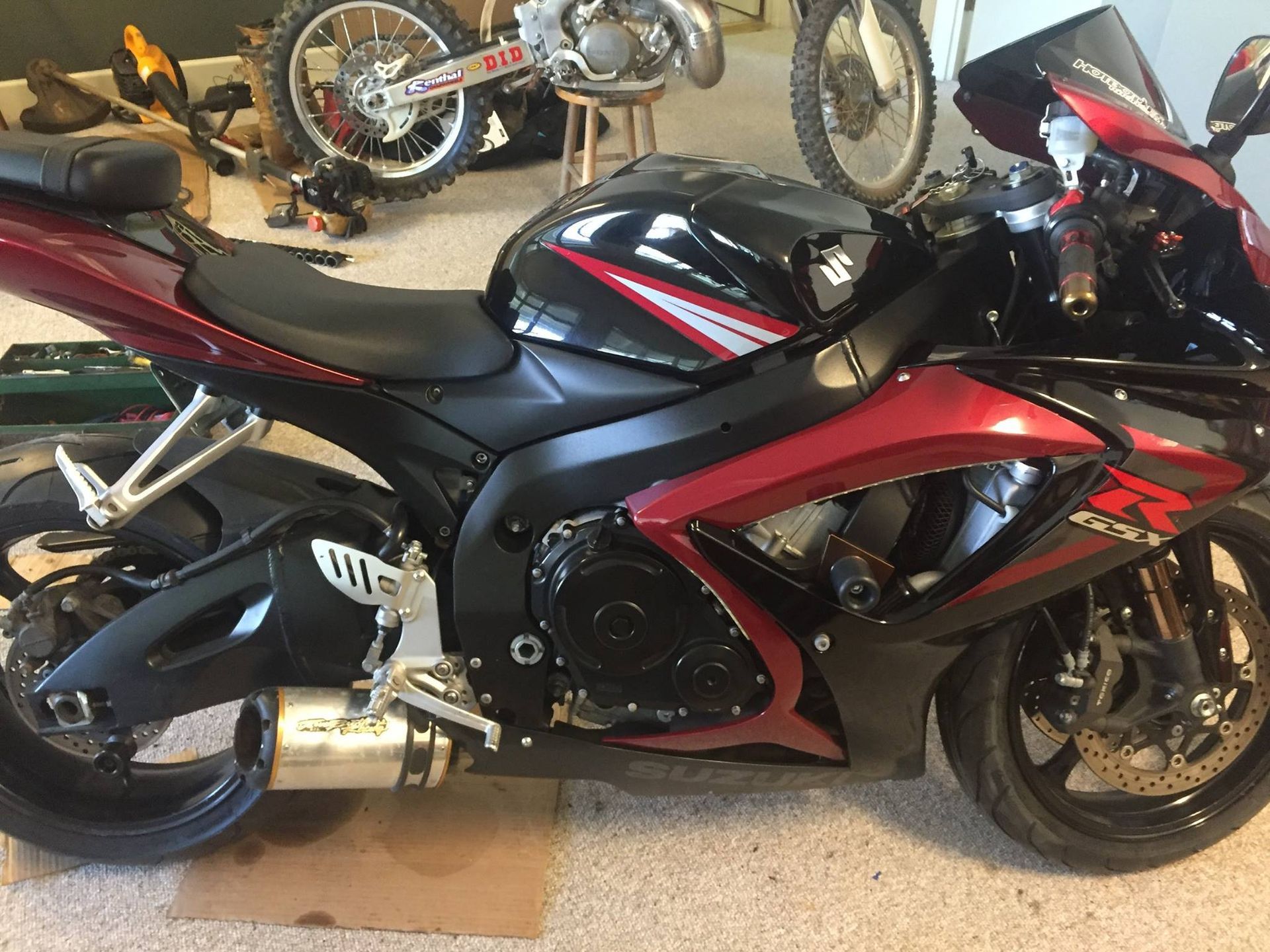 A black and red motorcycle is parked in a garage.