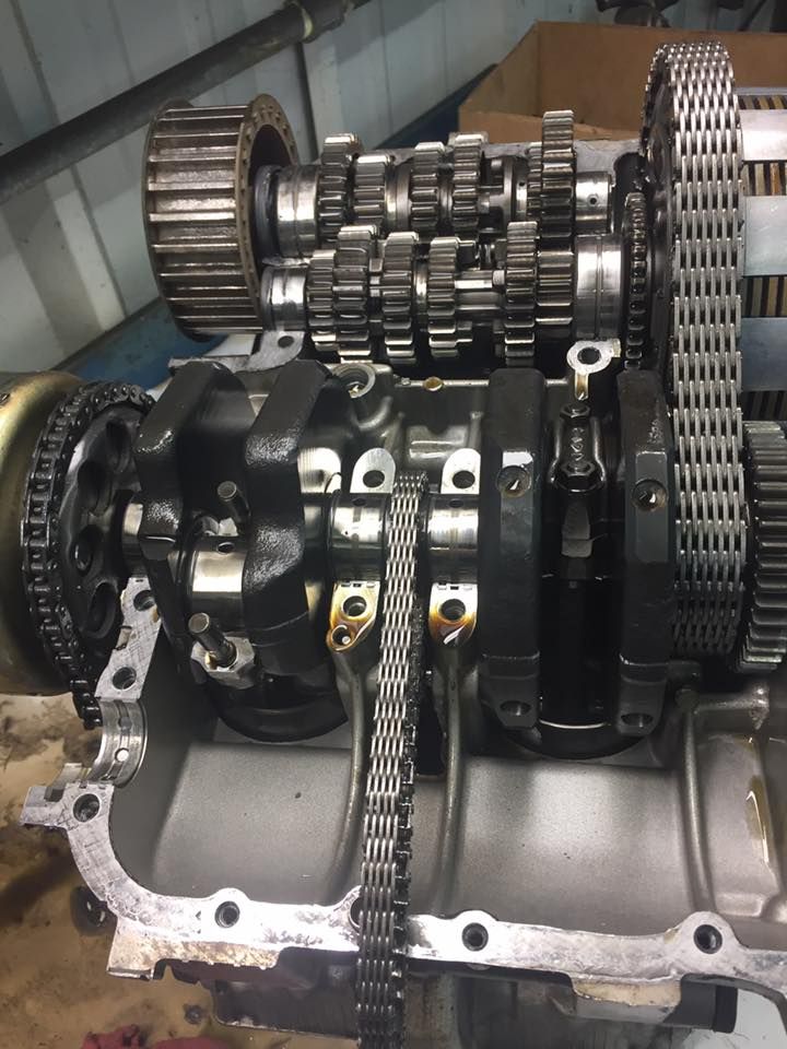 A close up of a motorcycle engine with gears and chains