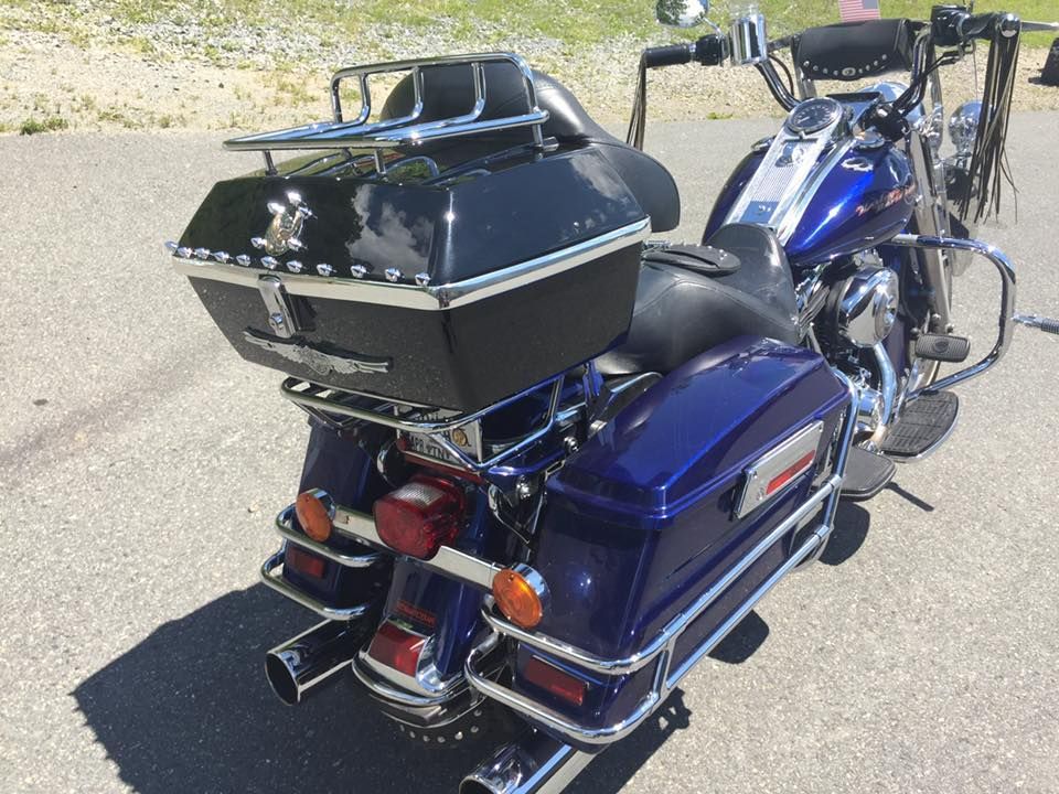A blue harley davidson motorcycle is parked on the side of the road