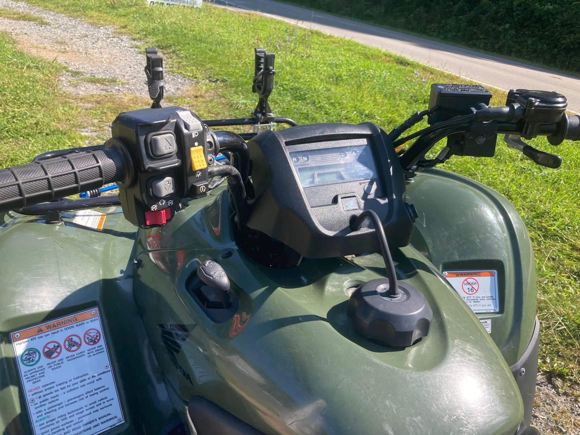 A green atv is parked in a grassy field
