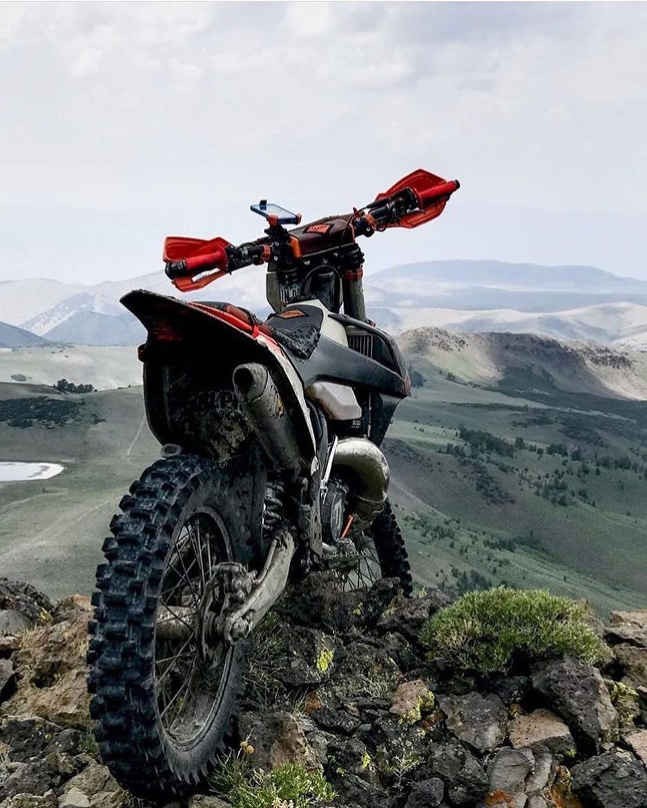 A dirt bike is parked on top of a rocky hill.