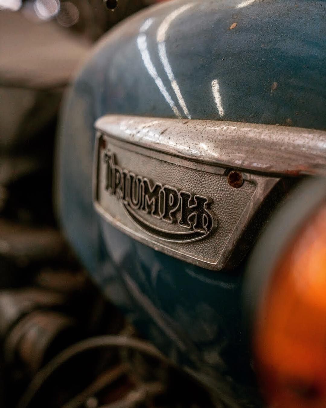 A close up of a triumph motorcycle 's fuel tank.