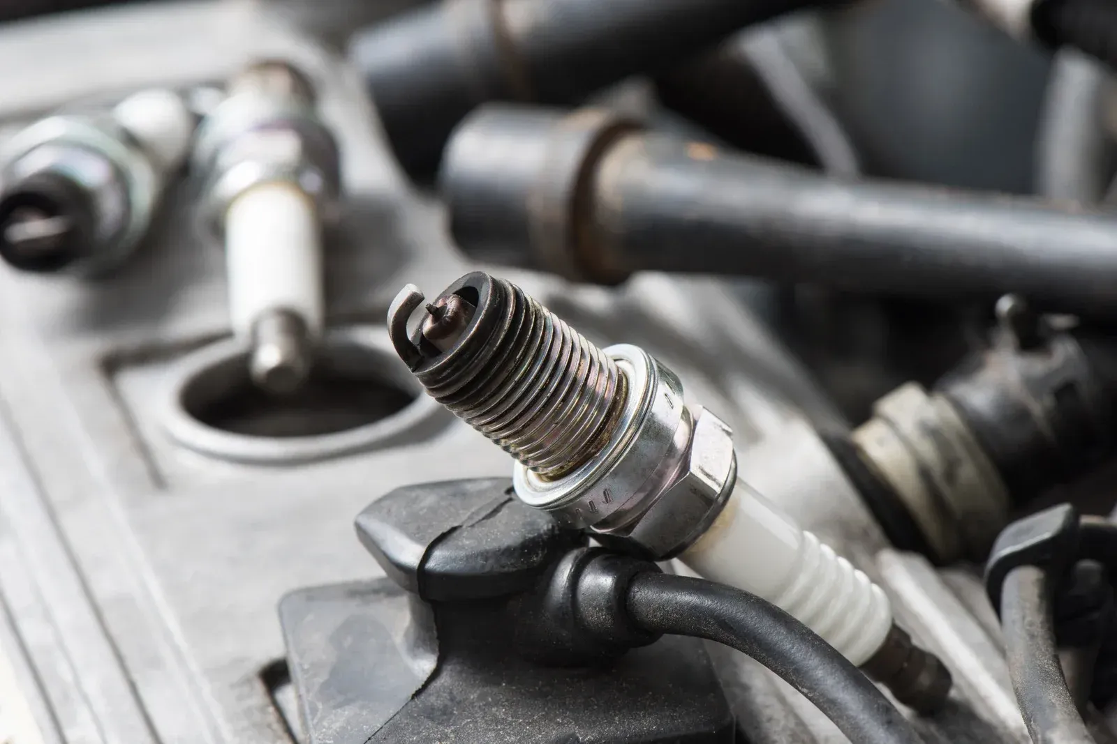 A close up of a spark plug on a car engine.