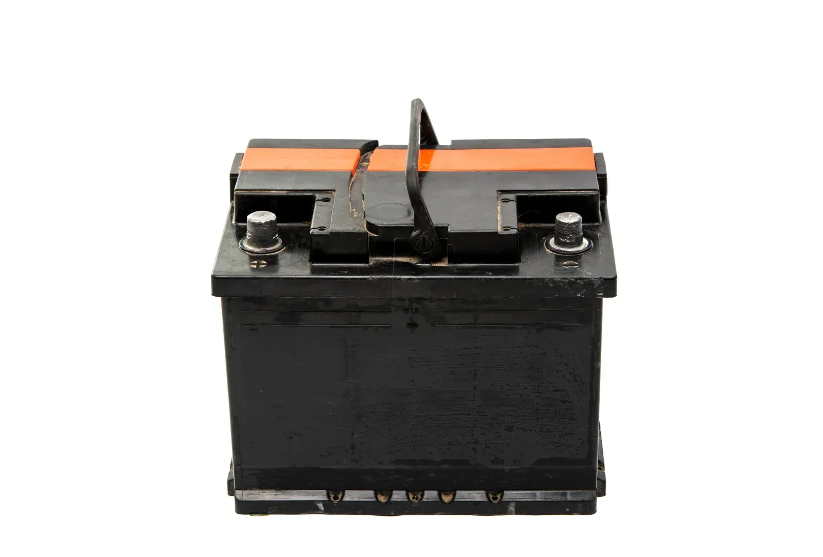 A car battery is sitting on a white surface.