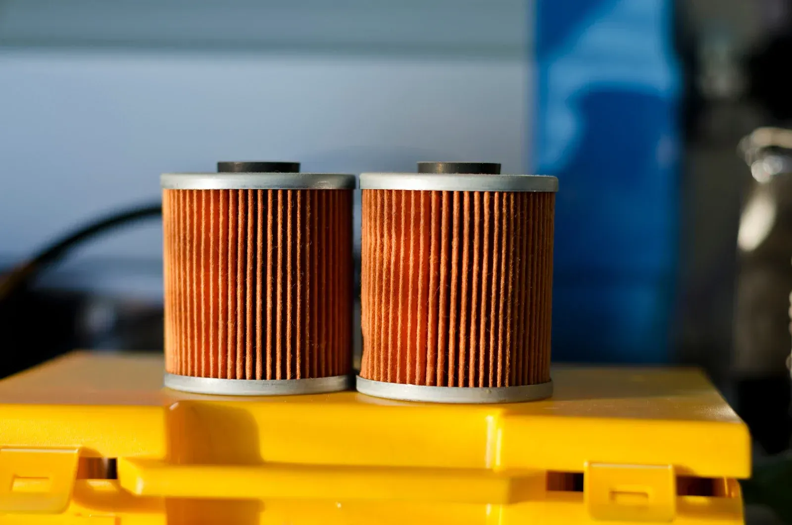Two oil filters are sitting on top of a yellow box.