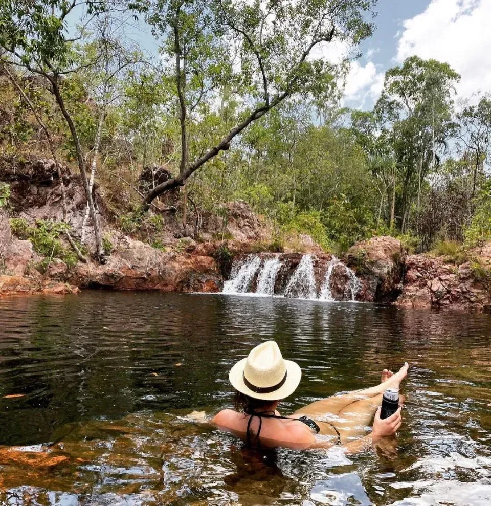 Woman in a Hat Floats in a Natural Pool, Small Waterfall — Litchfield VIP Tours In Darwin City, NT